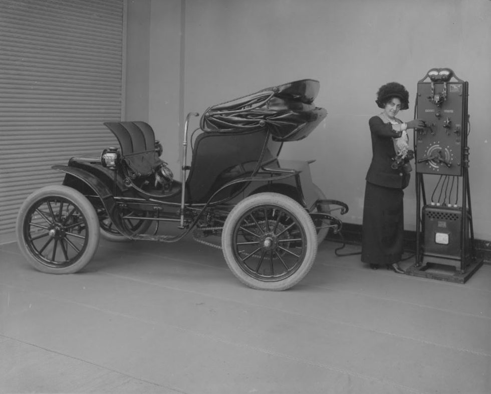 woman operating electric car charger, 1912